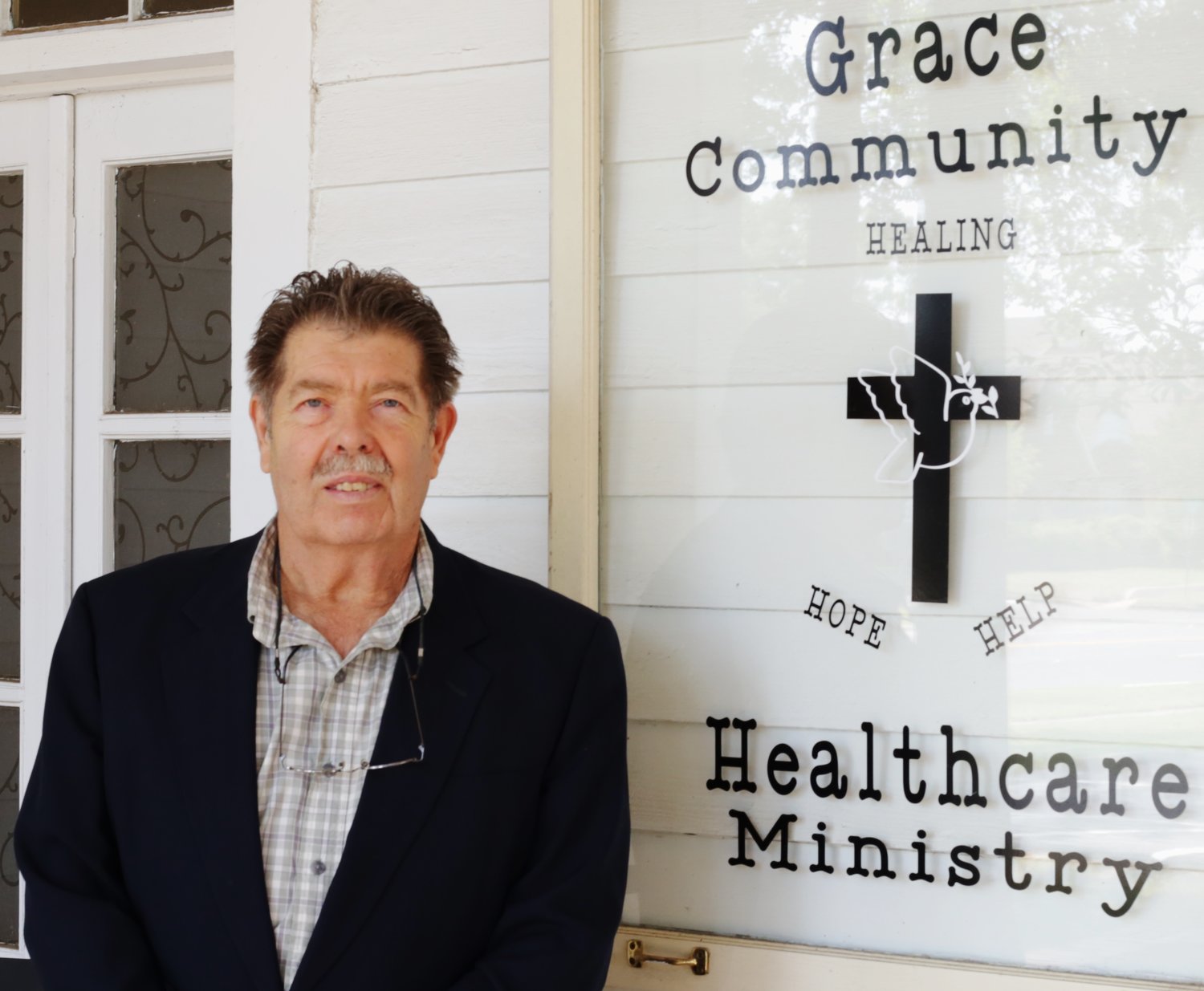 Administrator Jerry Brooks on the porch at Grace Health Care Ministry. (Monitor photo by John  Arbter)